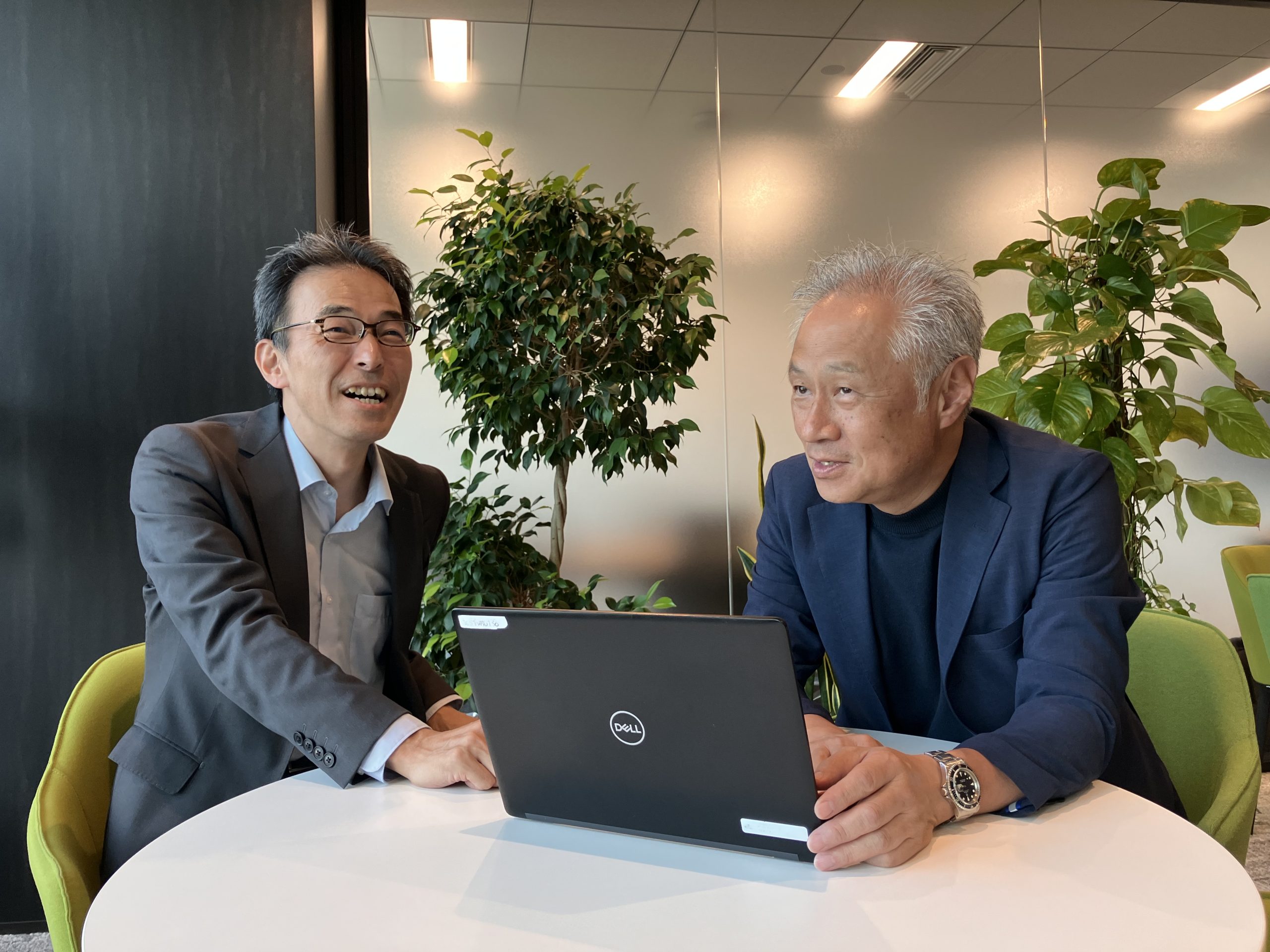左から㈱AOKIホールディングス 執行役員 デジタルサービス推進部部長 石松昇様、㈱AOKI ORIHICA商品構成部 エキスパート小林 千陽様がインタビュー中に笑顔になった瞬間。RFIDシステムを導入して、アパレル商品の管理がしやすくなった。